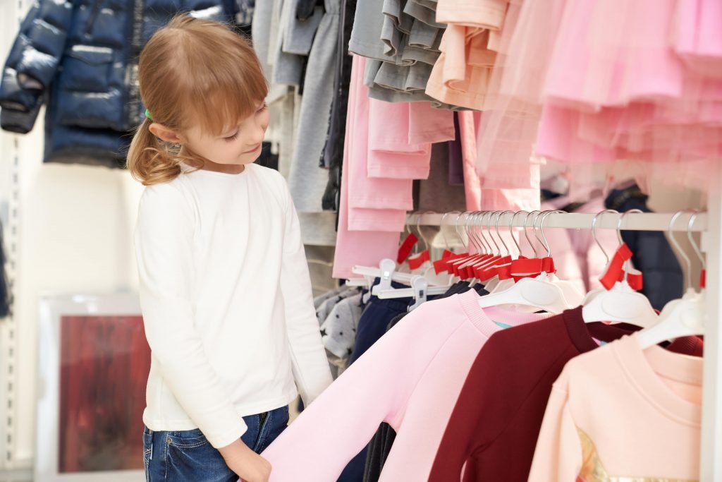 pretty child choosing clothing store min